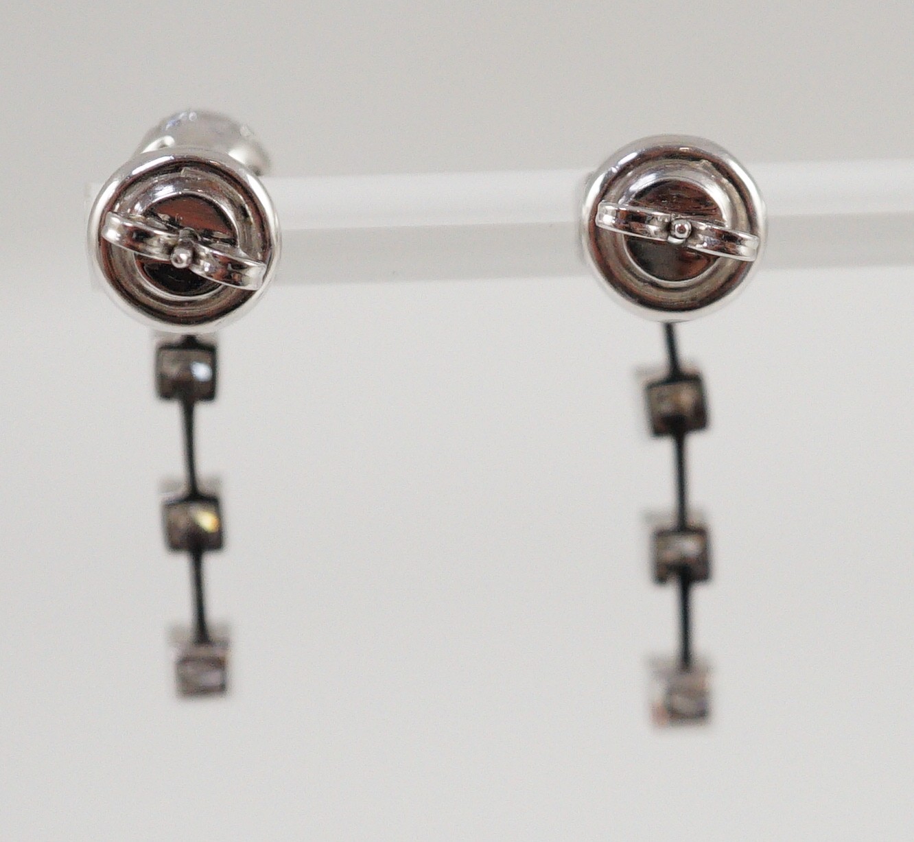 A modern pair of 18ct white gold, diamond cluster and three stone diamond drop set earrings